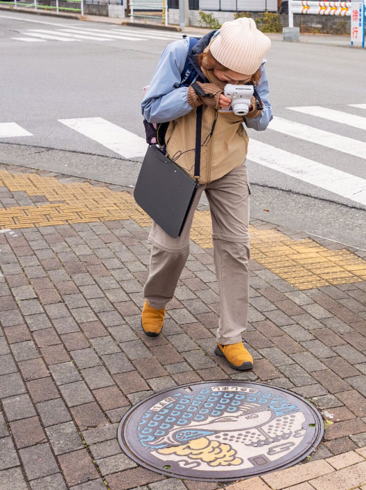 マンホールを写真撮影する参加者
